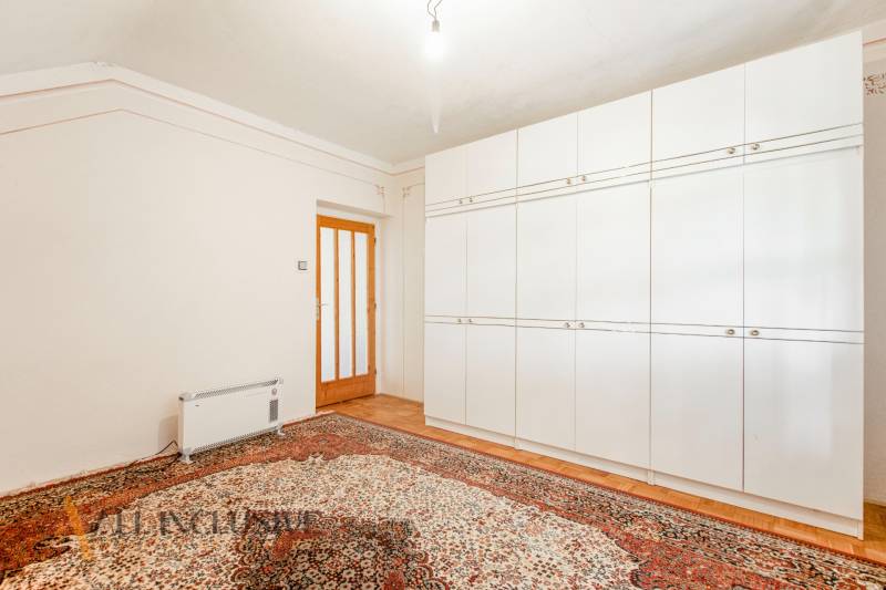 A room in a family house with a white wardrobe and a carpet.