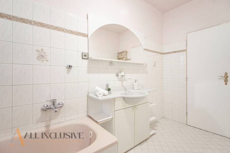 A bathroom in a family house with white tiles and light furniture.