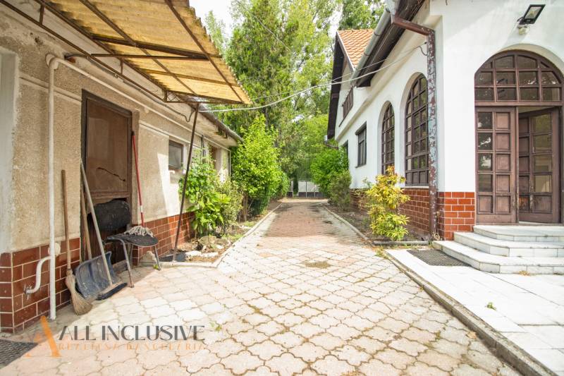 Courtyards of family houses in Žihárec with paving, greenery, and a shed.