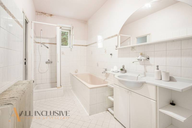 A bathroom in a family house with a bathtub, shower, and sink.