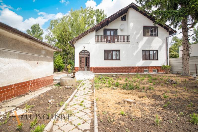 A family house in Žihárec with a white facade, a veranda, and a garden.