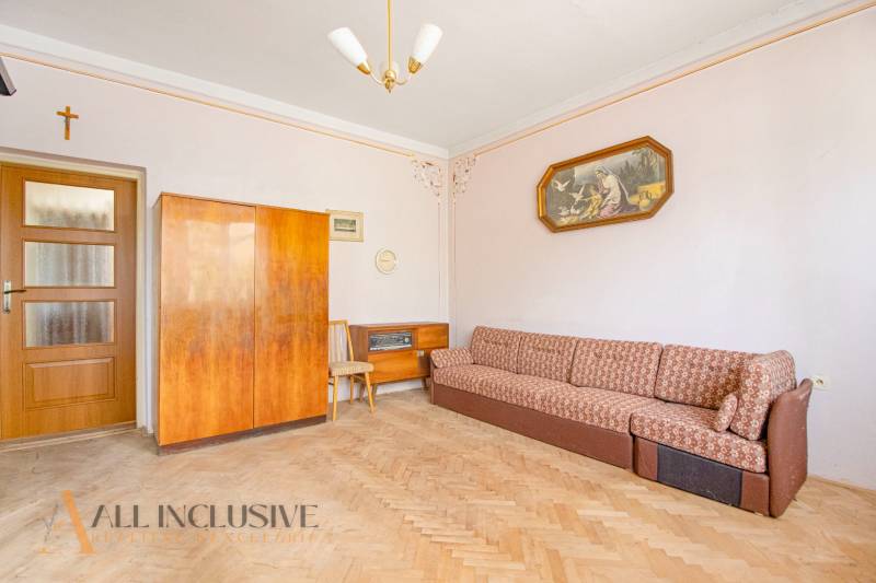 Living room in a family house with a sofa, wooden cabinet, and a painting.