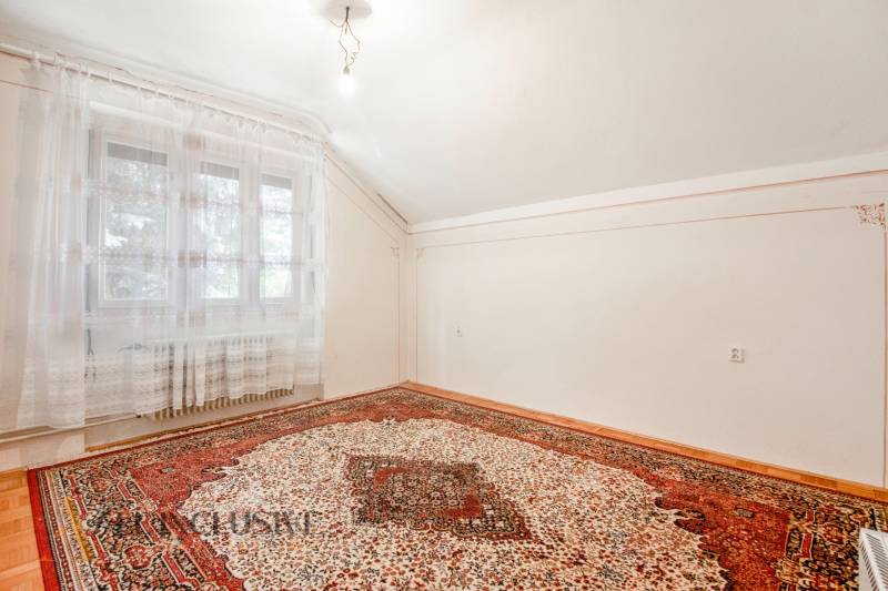 Interior of a family house with a carpet and a window, light walls and floors.