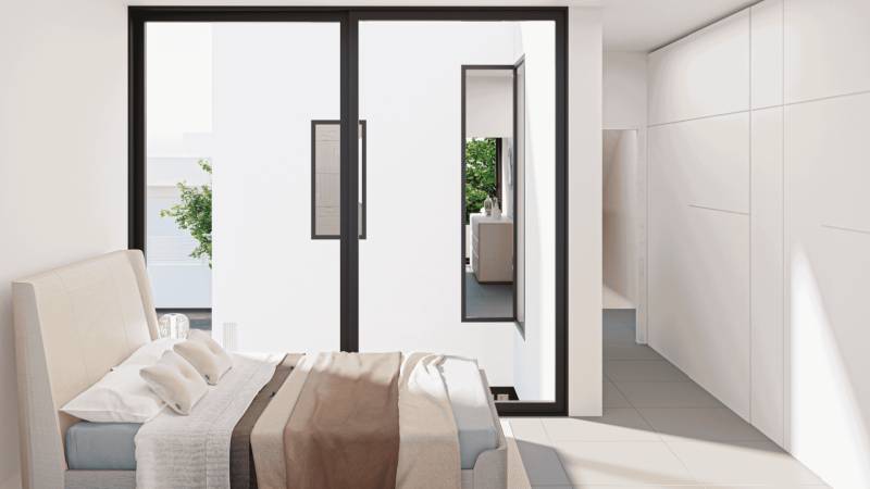 A bright bedroom in a family house with sliding doors and a view of greenery.