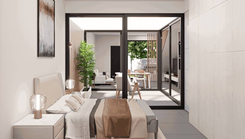 Bedroom in a family house with a view of the terrace and garden furniture.