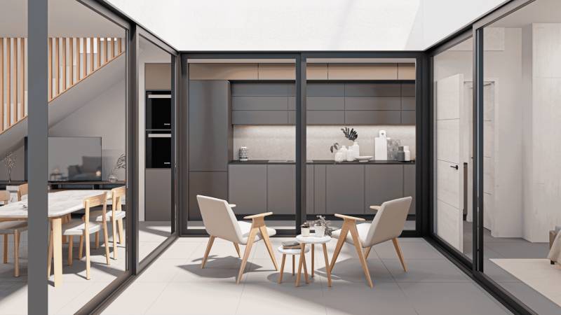 Interior of a family house with a kitchen, dining area, and a relaxation space with chairs.