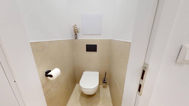Entrance hall with a toilet and subtle decorations in a 3-room apartment.