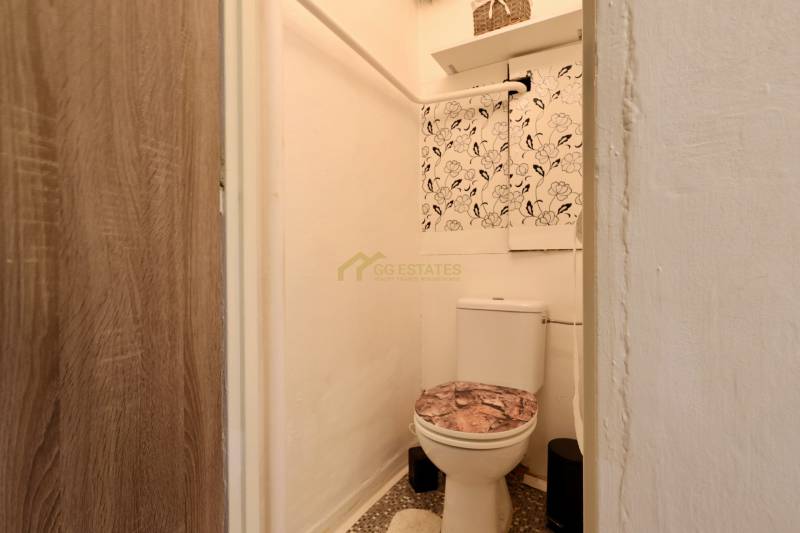 A toilet with decorative wallpaper in the interior of a 2-room apartment.