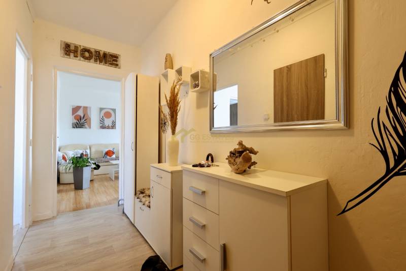 Entrance hall to a 2-room apartment with furniture and a mirror, at the entrance to the living room.