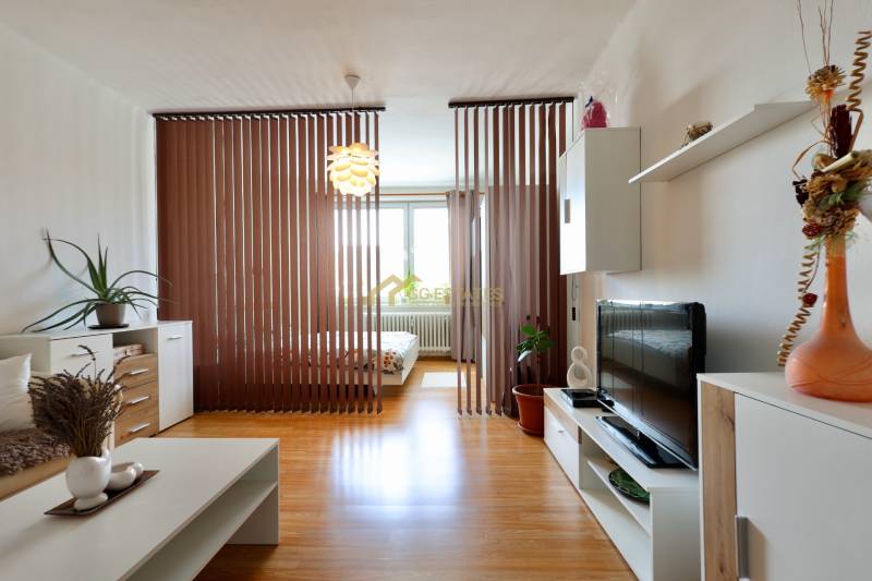 Interior of a 2-room apartment with wooden blinds, cabinets, and decorations.