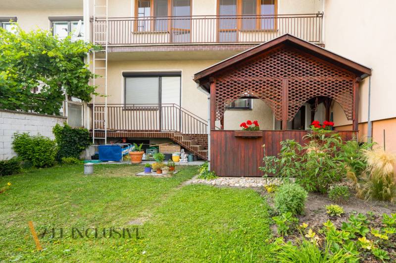 A family house in Dunajská Streda with a wooden veranda, garden, and balconies.