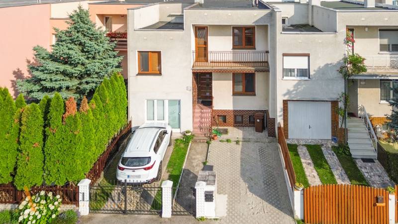 A family house in Dunajská Streda with a car parked on the driveway in front of the garden.