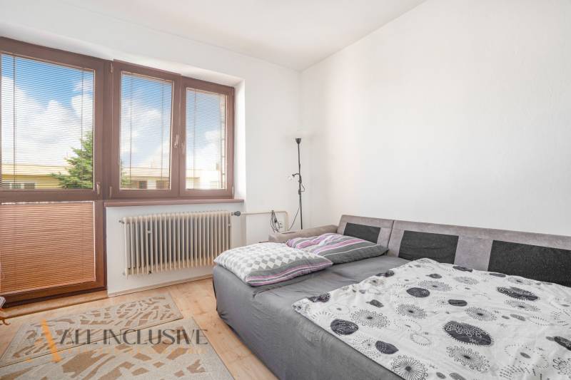 A room in a family house with a bed, a window, and a radiator.