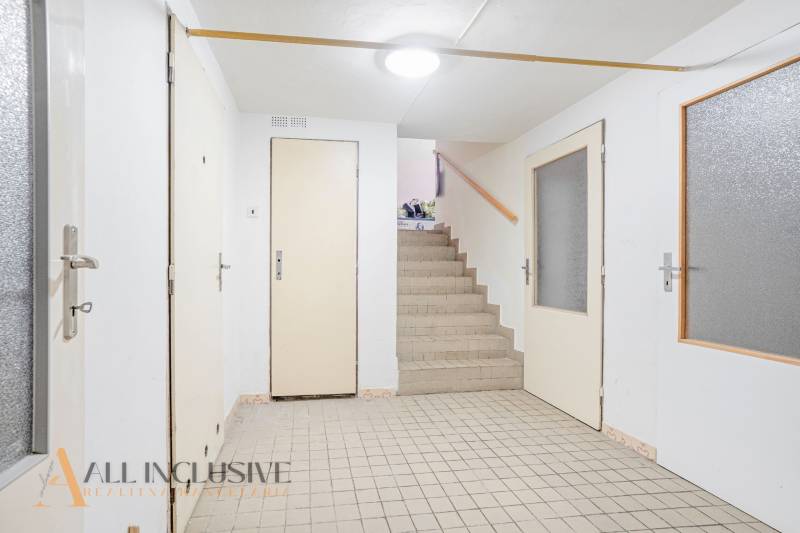 Interior with a hallway and staircase in a family house, white doors and tiles.