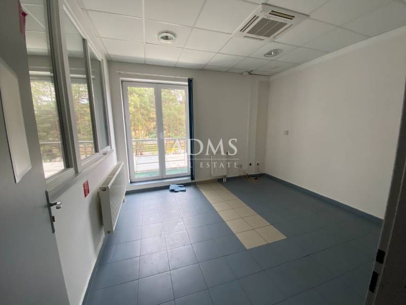 An empty room with a tiled floor, windows, radiator, air conditioning, warehouses, and halls.