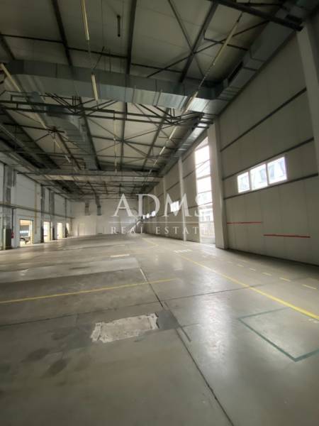 A spacious interior with skylights and a concrete floor in a warehouse and hall.