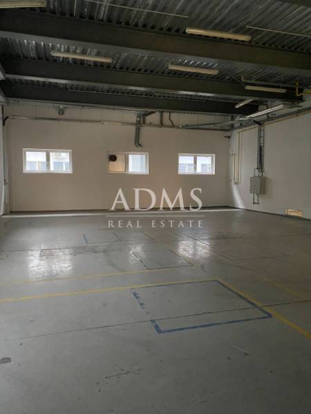 A space with a gray floor and white walls, suitable for warehouses and halls.