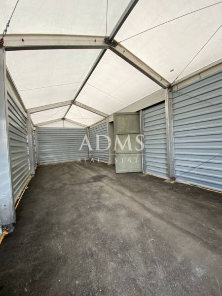 The interior of a storage hall with a steel structure and a white ceiling.