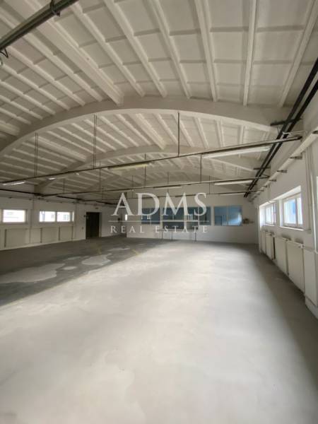 Spacious interior with large windows and an arched ceiling in Warehouses and Halls.