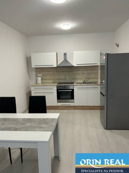 A kitchen with a dining table in a 2-room apartment with modern furnishings.
