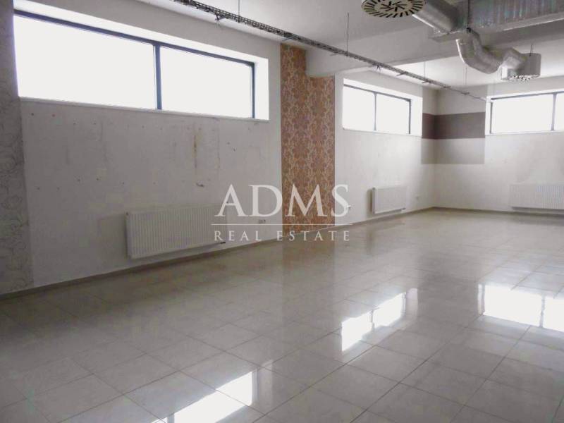 Spacious commercial premises with windows, tiling, and an HVAC system, suitable for rent.