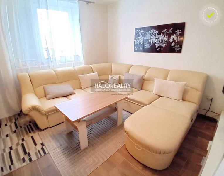 A corner sofa with cushions and a coffee table in the living room of a family house.