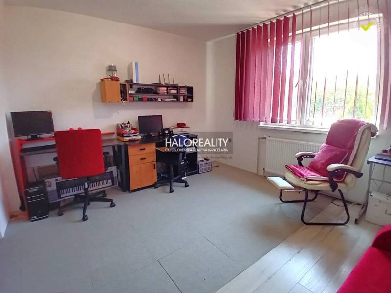 A study in a family house with computers, office chairs, and a window with vertical blinds.