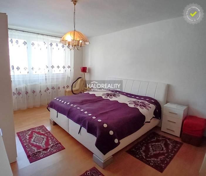 Bedroom in a family house with a large bed, nightstands, and decorative rugs.
