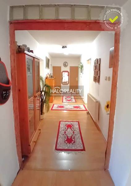 Interior of a family house with wooden furniture, a hallway, and rugs on the floor.