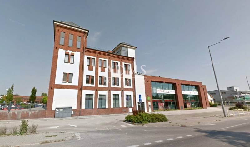 A building with commercial spaces on Bratislavská Street in Šamorín, with glass and brick facades.