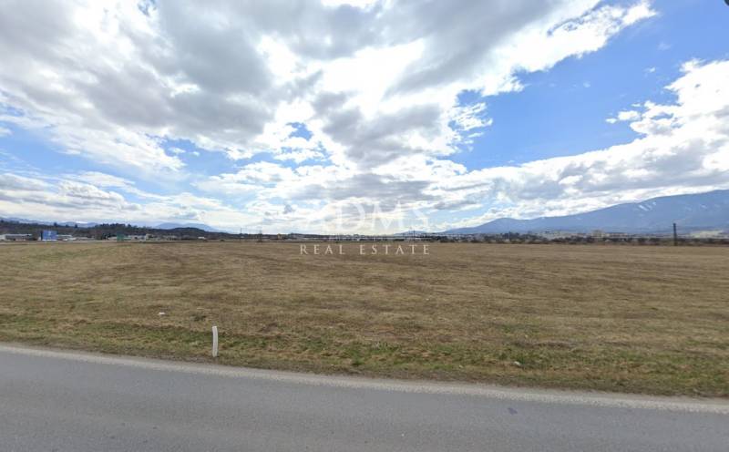 A vast field under a cloudy sky in Sučany, ideal for commercial purposes.