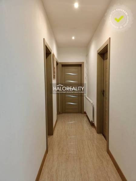 Hallway with light walls and wooden doors in a family house.