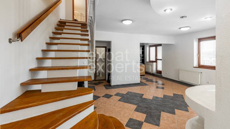 A staircase leading to an offering space in a 5 or more room apartment with windows.