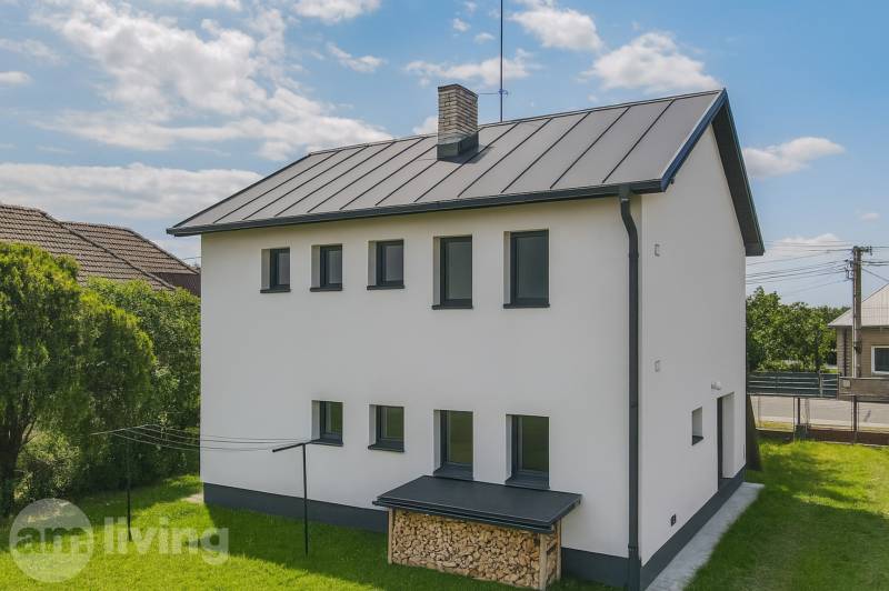 A family house in Pruské with a white facade, wood for heating, and a lawn.