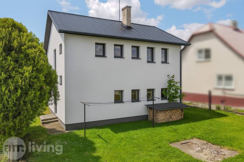 A family house in Pruské with a woodshed and a garden surrounded by trees.