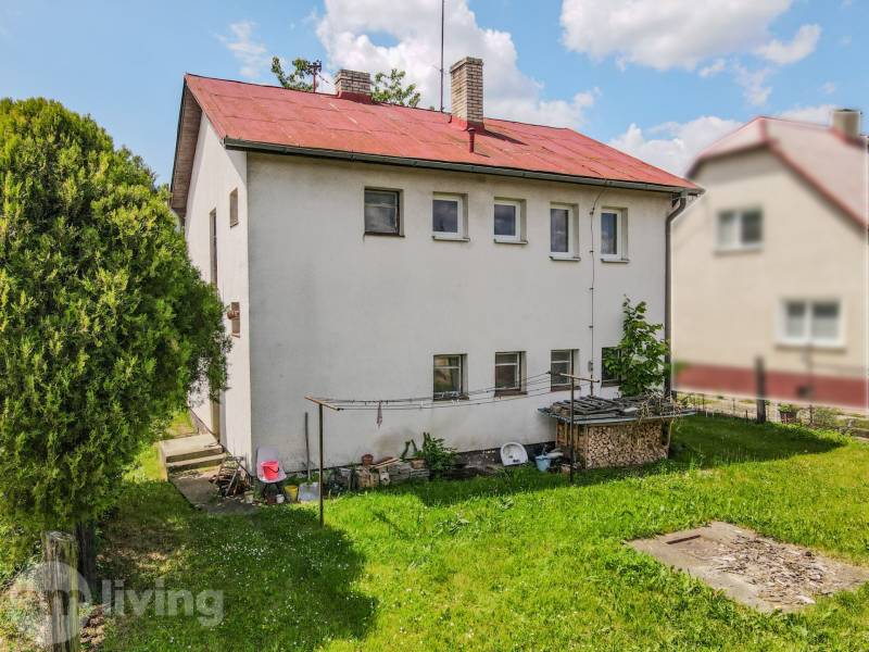 A family house in Pruské with a garden, white facade, and red roof.