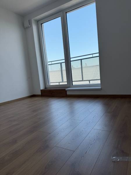 A room with a wooden floor and a large window, 2-room apartment.
