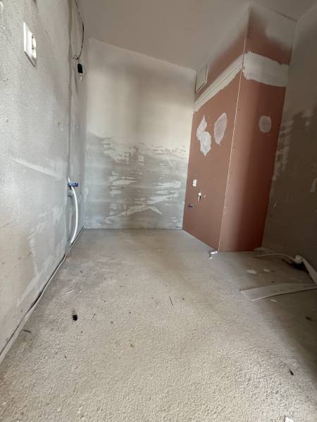 Unfinished room in a 2-room apartment with unplastered walls and pipes.