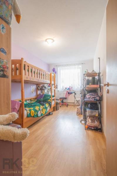 A bright hallway in a 3-room apartment with wooden flooring, a bench, and a wardrobe.