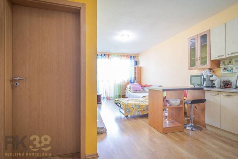A kitchen in a 3-room apartment with white cabinets and built-in appliances.