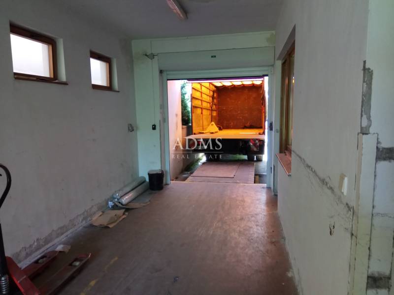 Production premises with a garage door and a parked truck for loading goods.