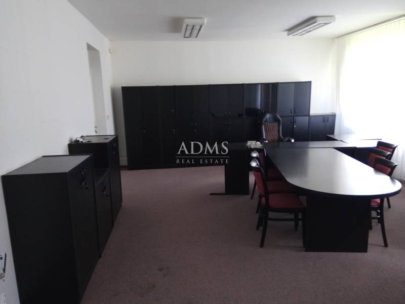 Office with black furniture and a large table in the production area.