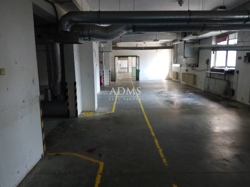 Industrial hall with ventilation pipes and floor markings in the production area.