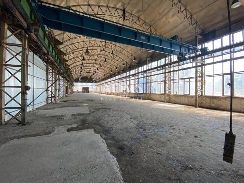 A spacious interior in an industrial hall with storage options and large windows.