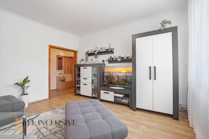 Living room in a two-room apartment with white furniture and decorations.