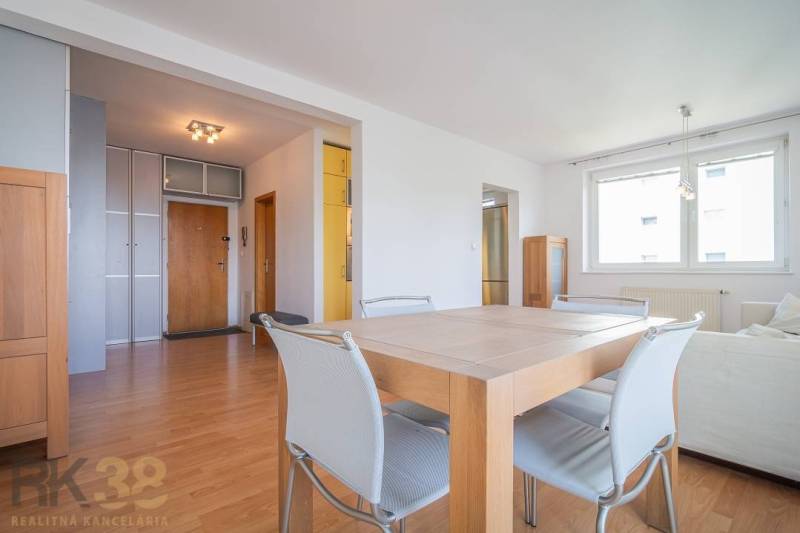 Dining table with chairs in a bright living room of a three-room apartment.