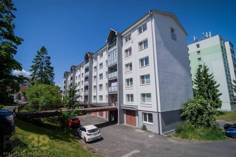 Apartment building on Levočská Street in Poprad with trees and parked cars.