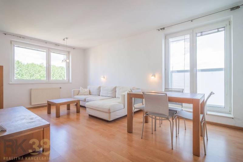 Living room in a three-room apartment with a corner sofa and wooden furniture.
