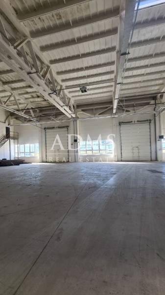 Industrial interior with a large open space and garage doors, suitable for warehouses and halls.