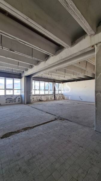 A view into the abandoned interior of a building with old tiles, warehouses, and halls.